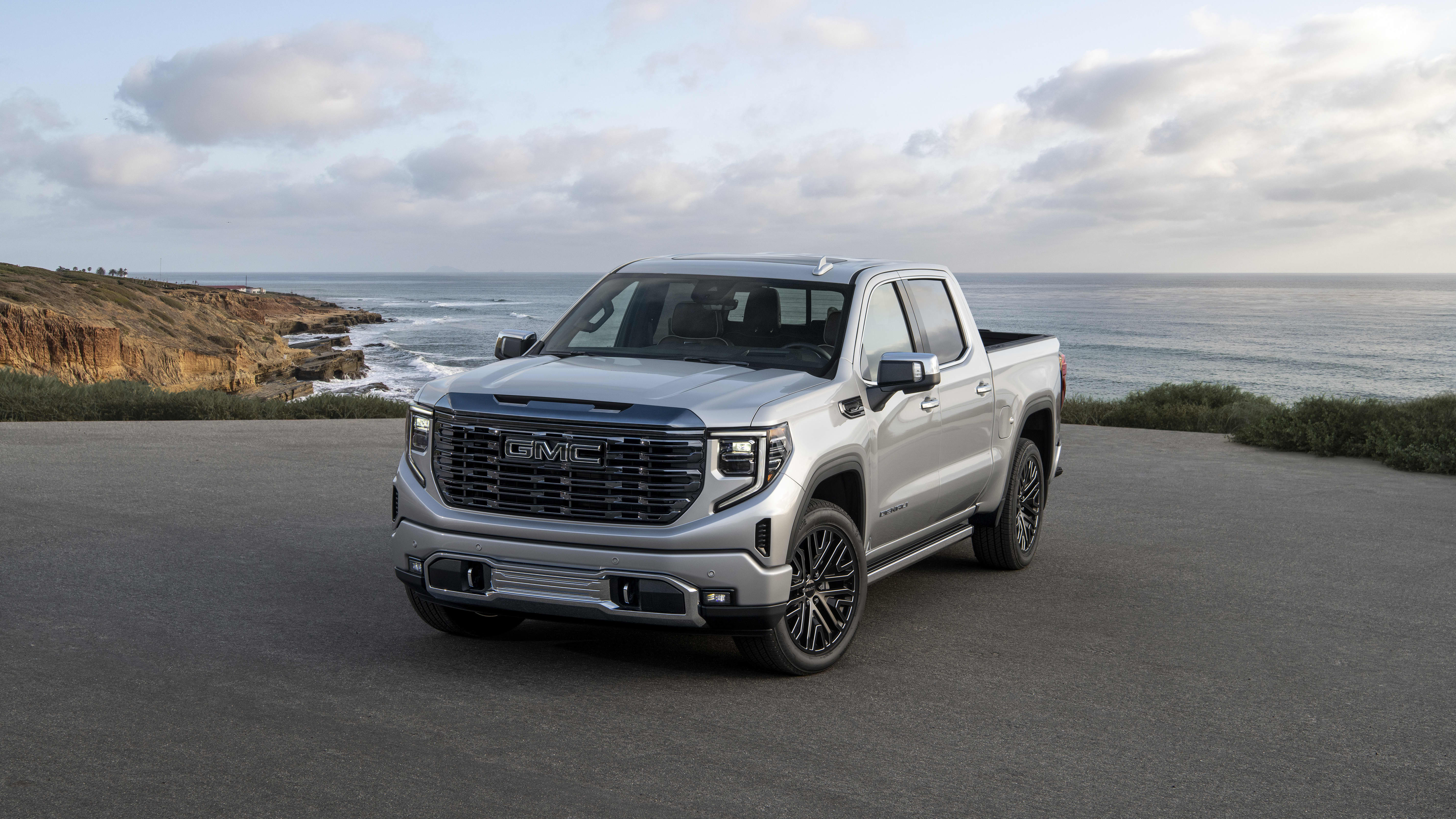 media image of the 2022 GMC Sierra Denali Ultimate parked on a cliffside road on the California coast
