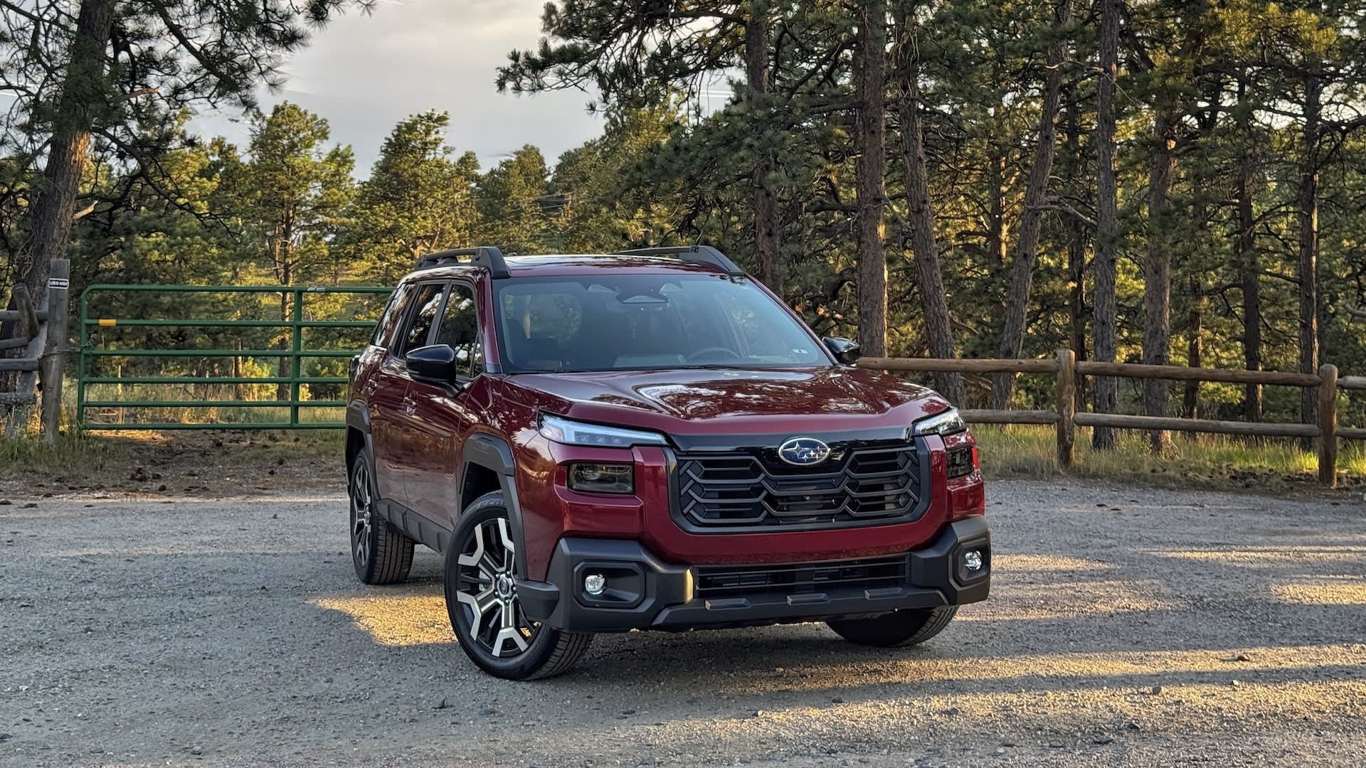 red Subaru outback with a forrest backdrop