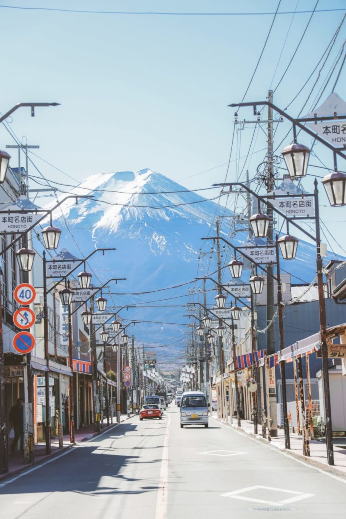 busy Japanese street with huge snow-capped mountain in the background