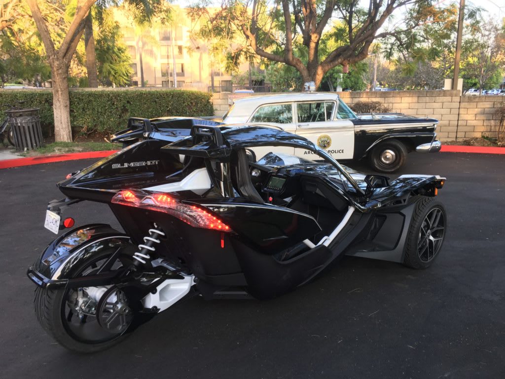 Polaris Slingshot Grand Touring beside a police car