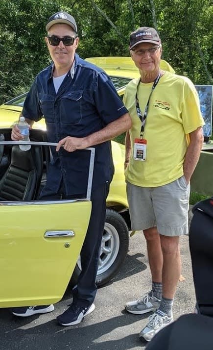 Datsun racer and collector Adam Carolla attended the event and helped with the judging. In the photo with his bodyguard.