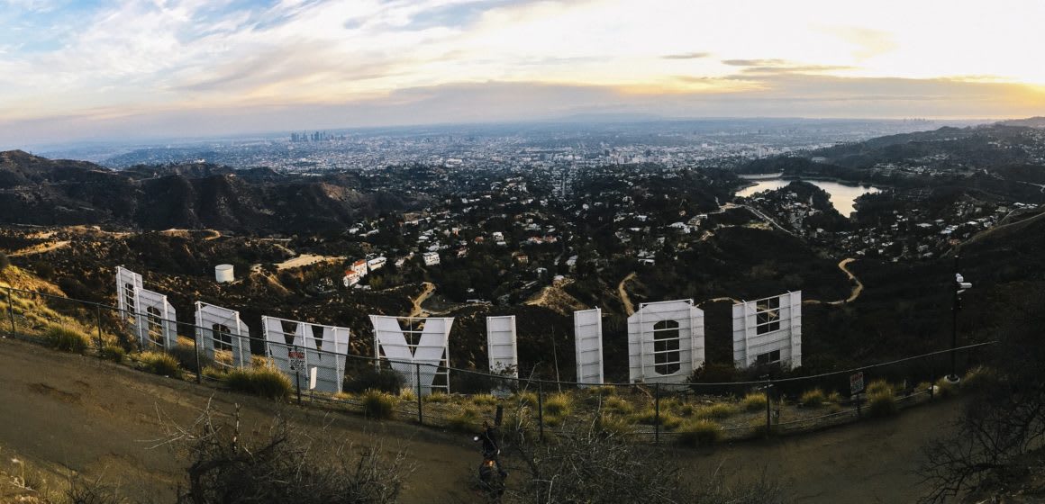 Image of the Hollywood sign in Los Angeles, taken from behind the sign, with the LA skyline in the background