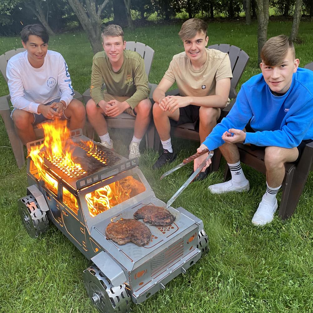 Four teenagers sitting around a sheet metal grill that looks like a Jeep Wrangler
