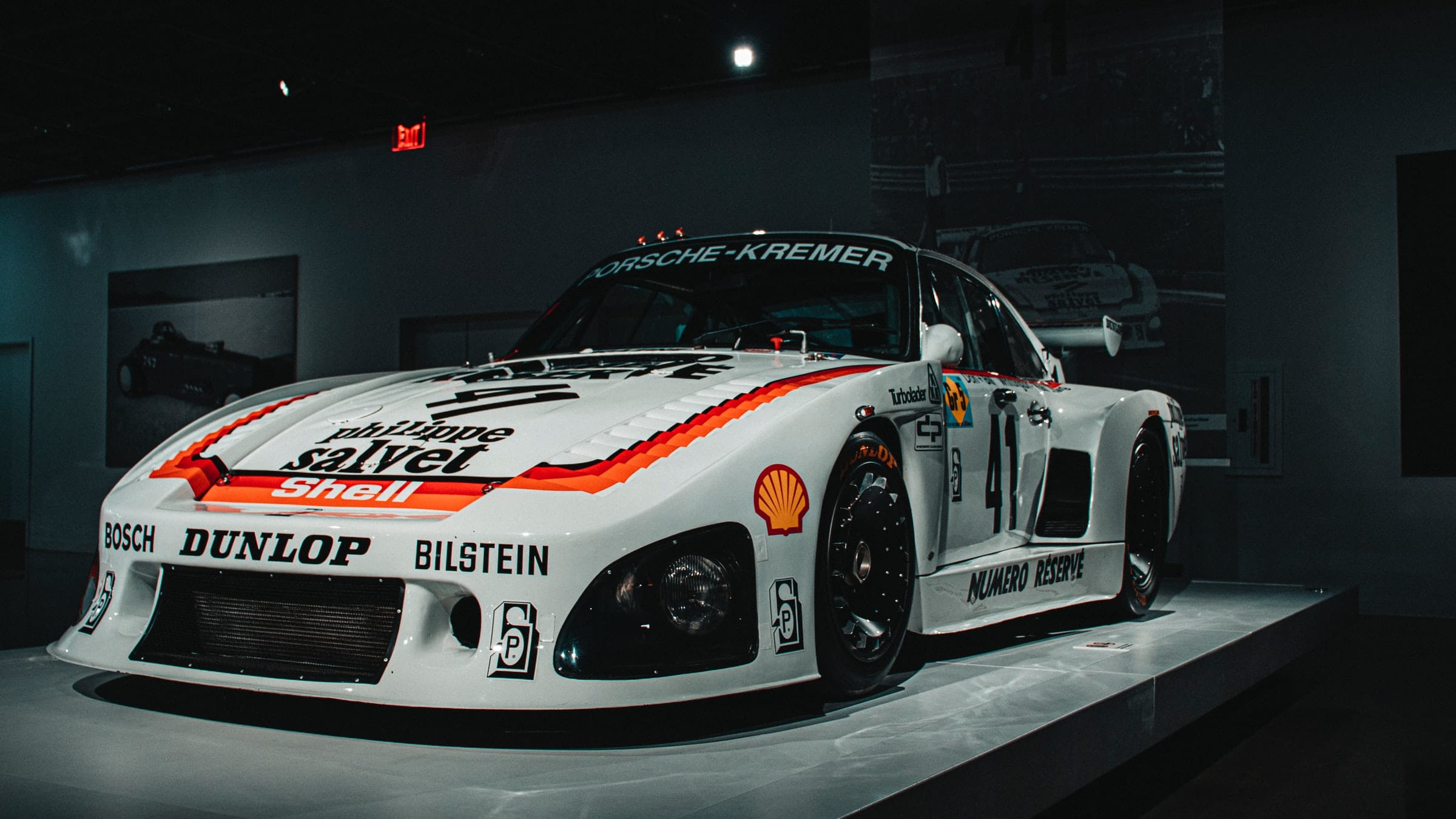 a white Porsche with logos and decals on display at The Petersen Automotive Museum in Los Angeles