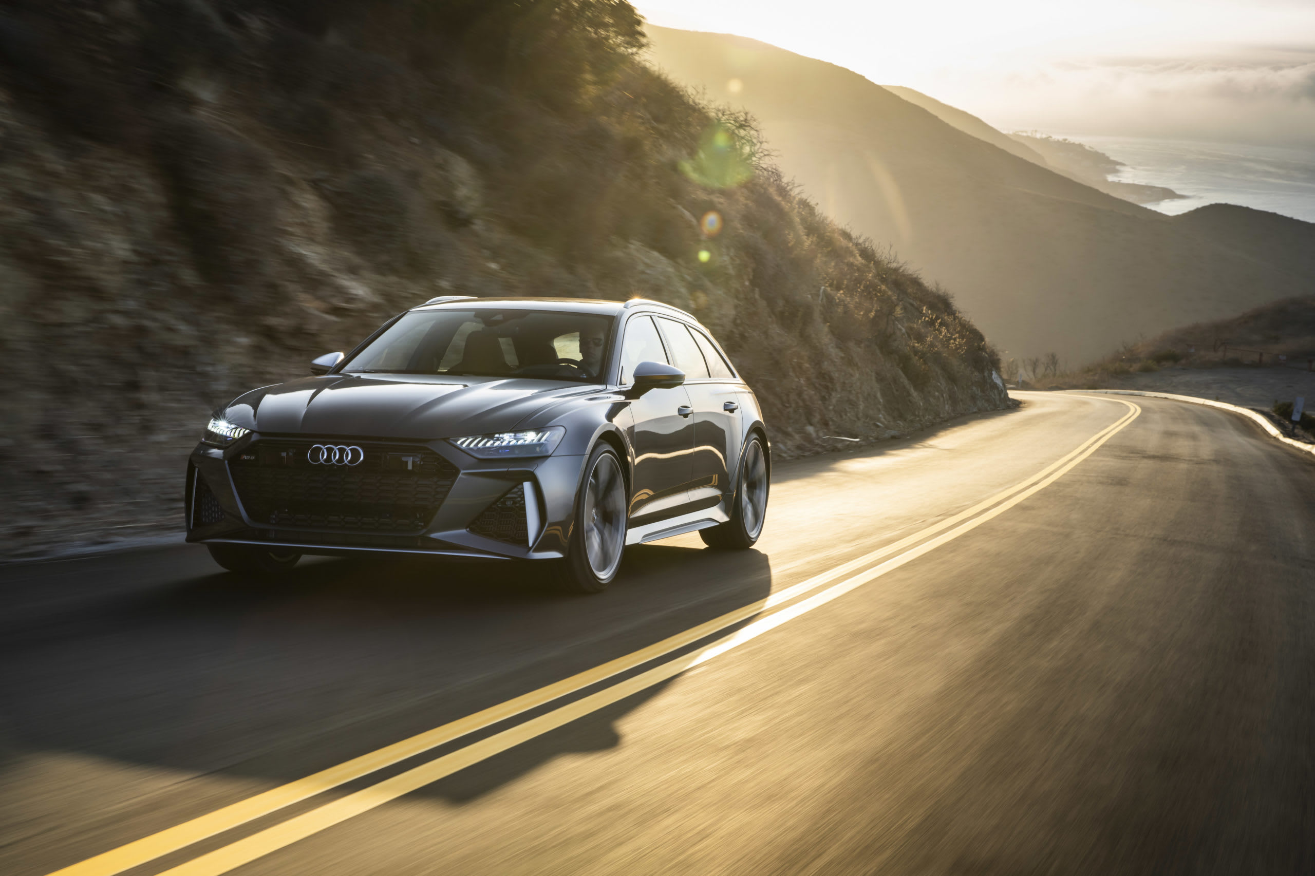 grey Audi RS6 on a cliff-side road.
