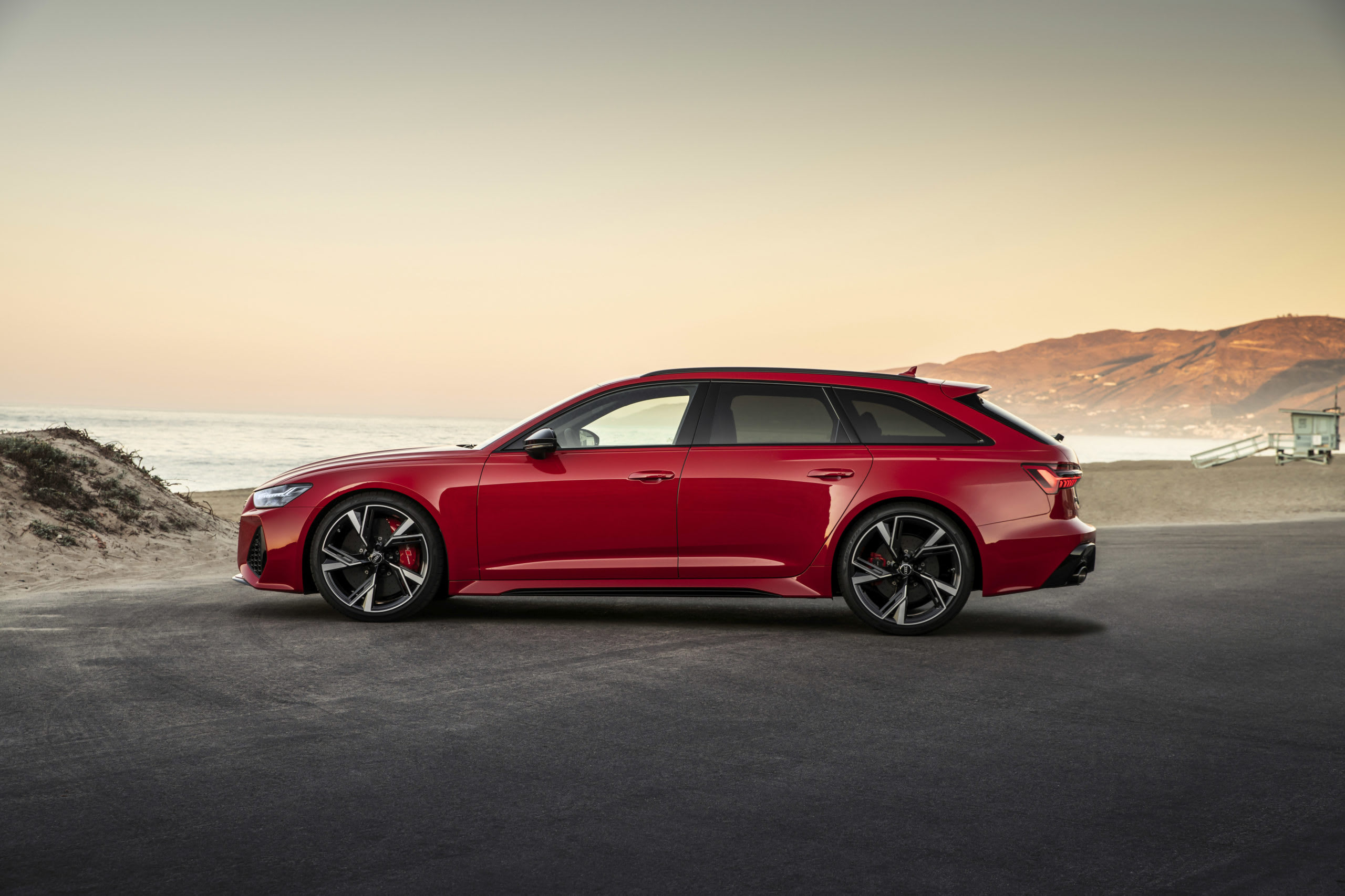 a red Audi RS6 Avant station wagon at the beach.