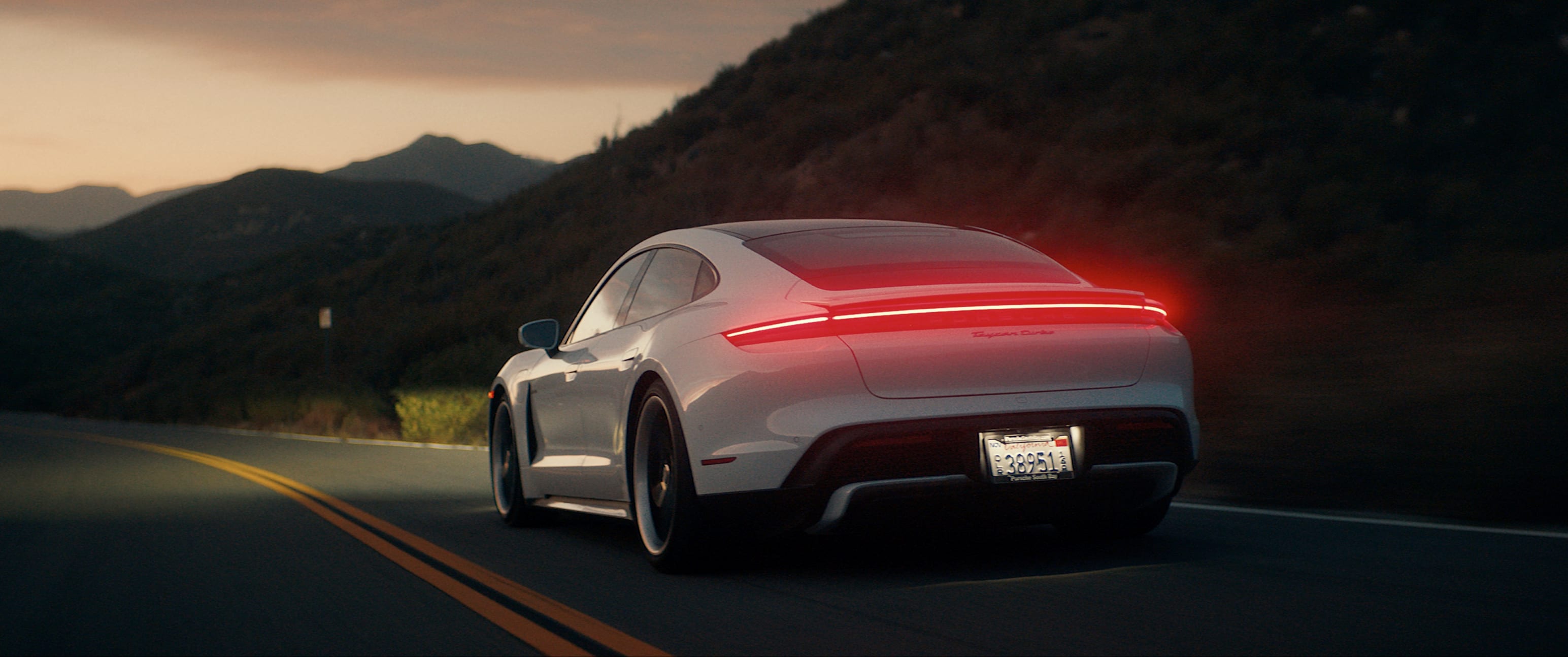 porsche taycan driving away in the evening light