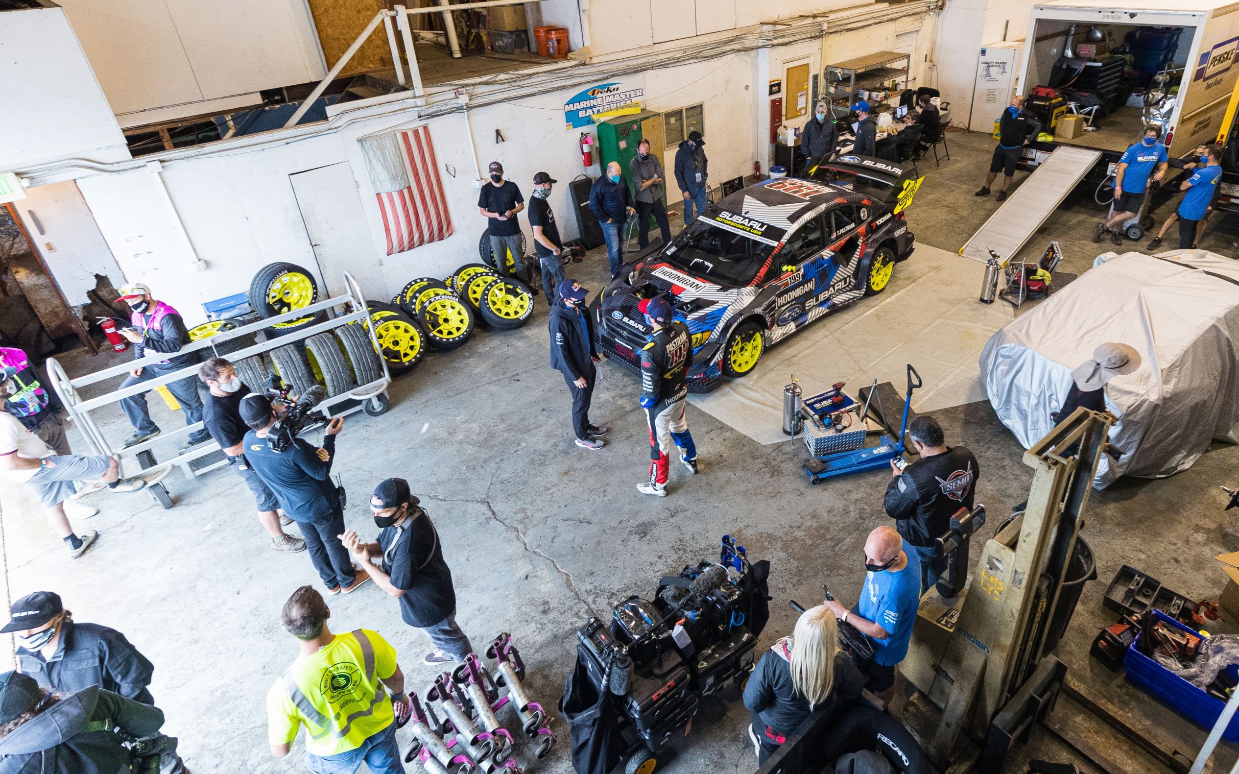 the gymkhana team in the garage with the gymkhana car
