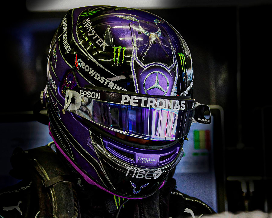 race driver with a purple helmet with the Petronas logo on it