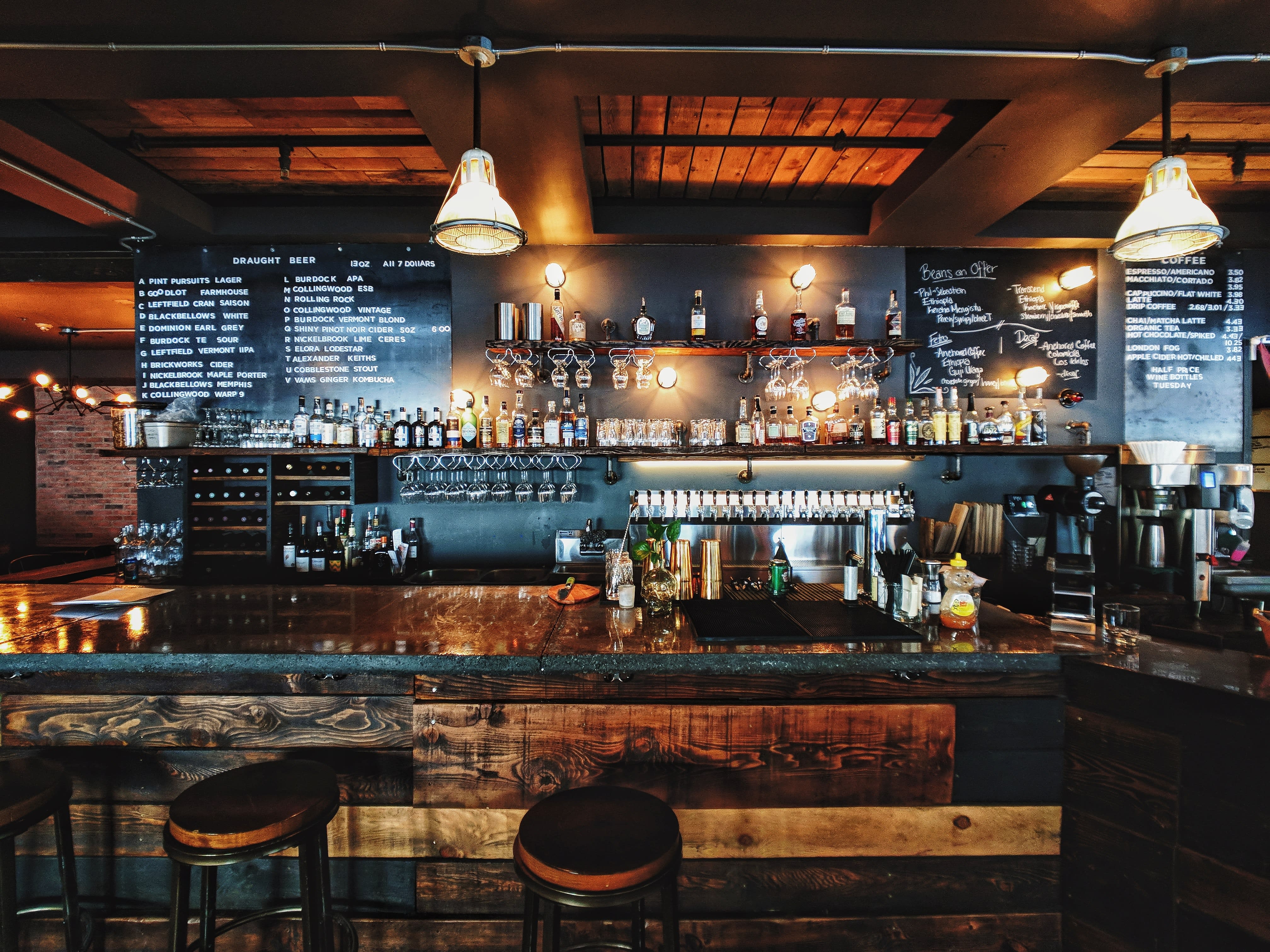 image of a rustic bar with wooden panels and chalkboard menus