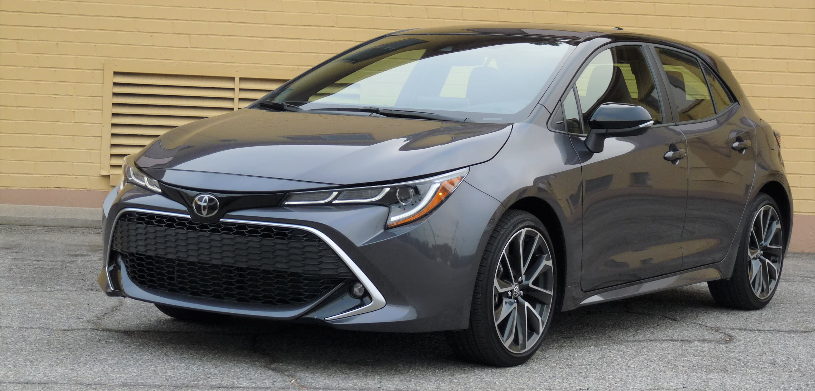 2021 Toyota Carolla Hatchback sitting idle with a yellow wall in the background.