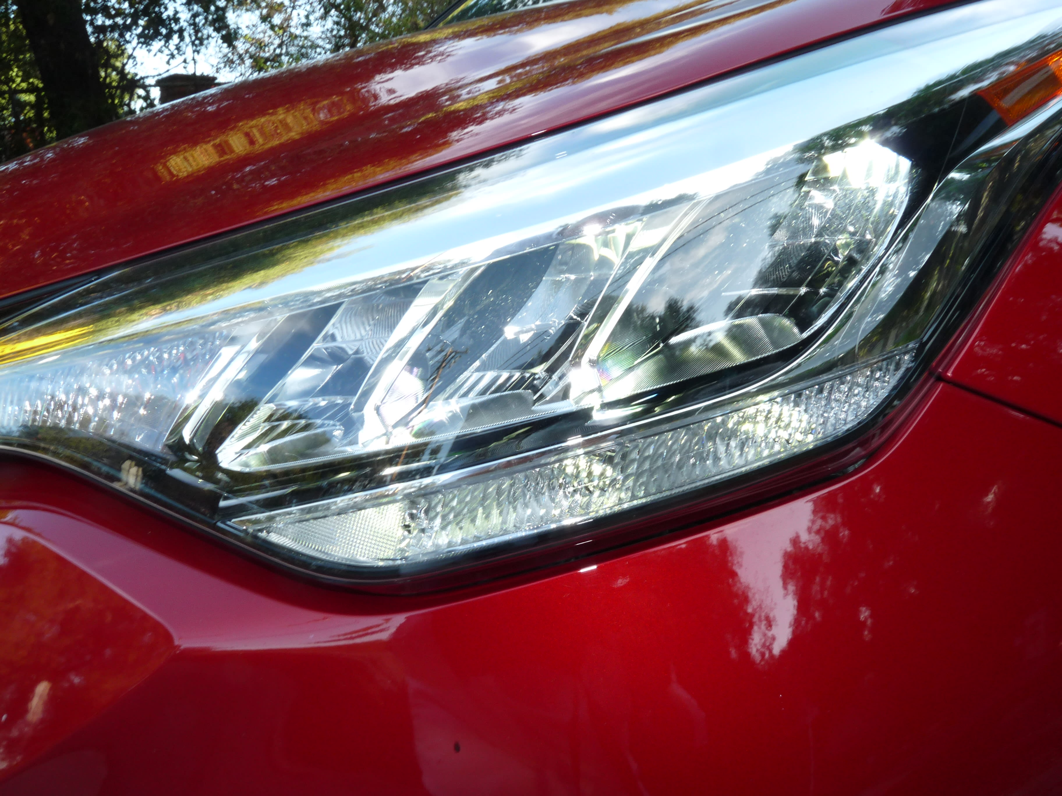 close-up shot of the left headlight of the red 2021 Toyota CH-R
