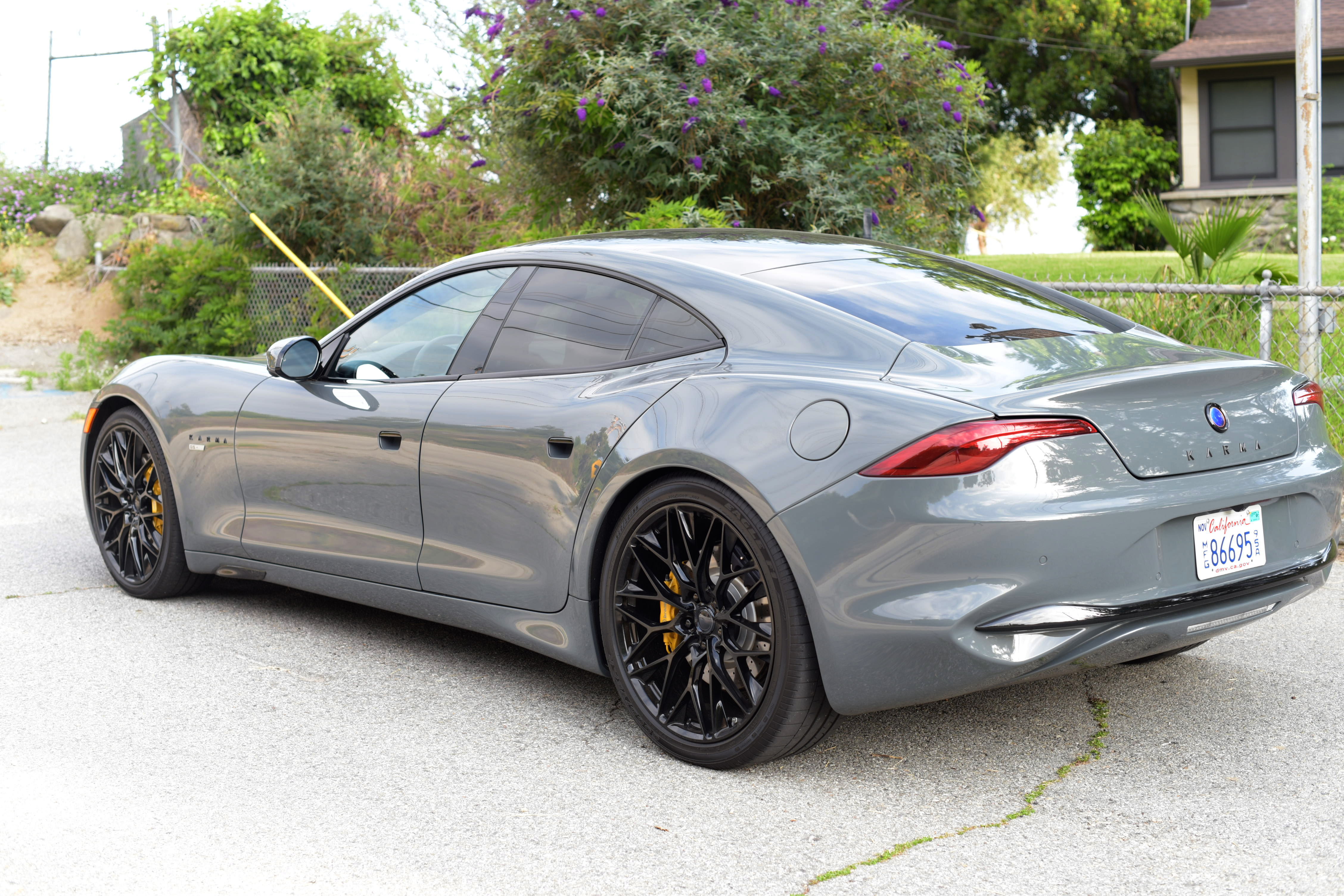 the rear and left side of a gray Karma GS-6 parked on the side of the road