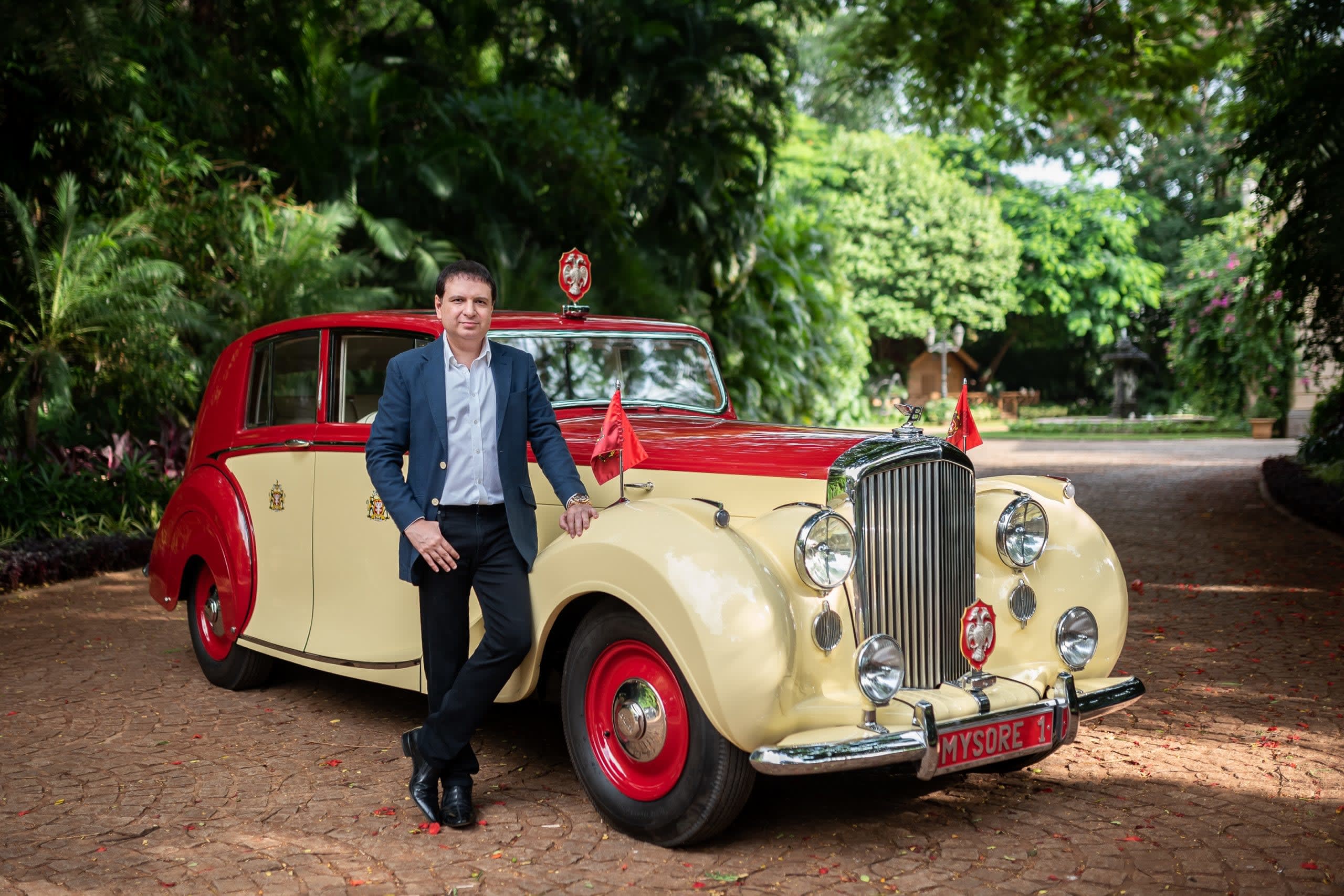 a classic yellow and red 1949 Bentley vi Touring Saloon with its owner at the 2021 Salon Prive