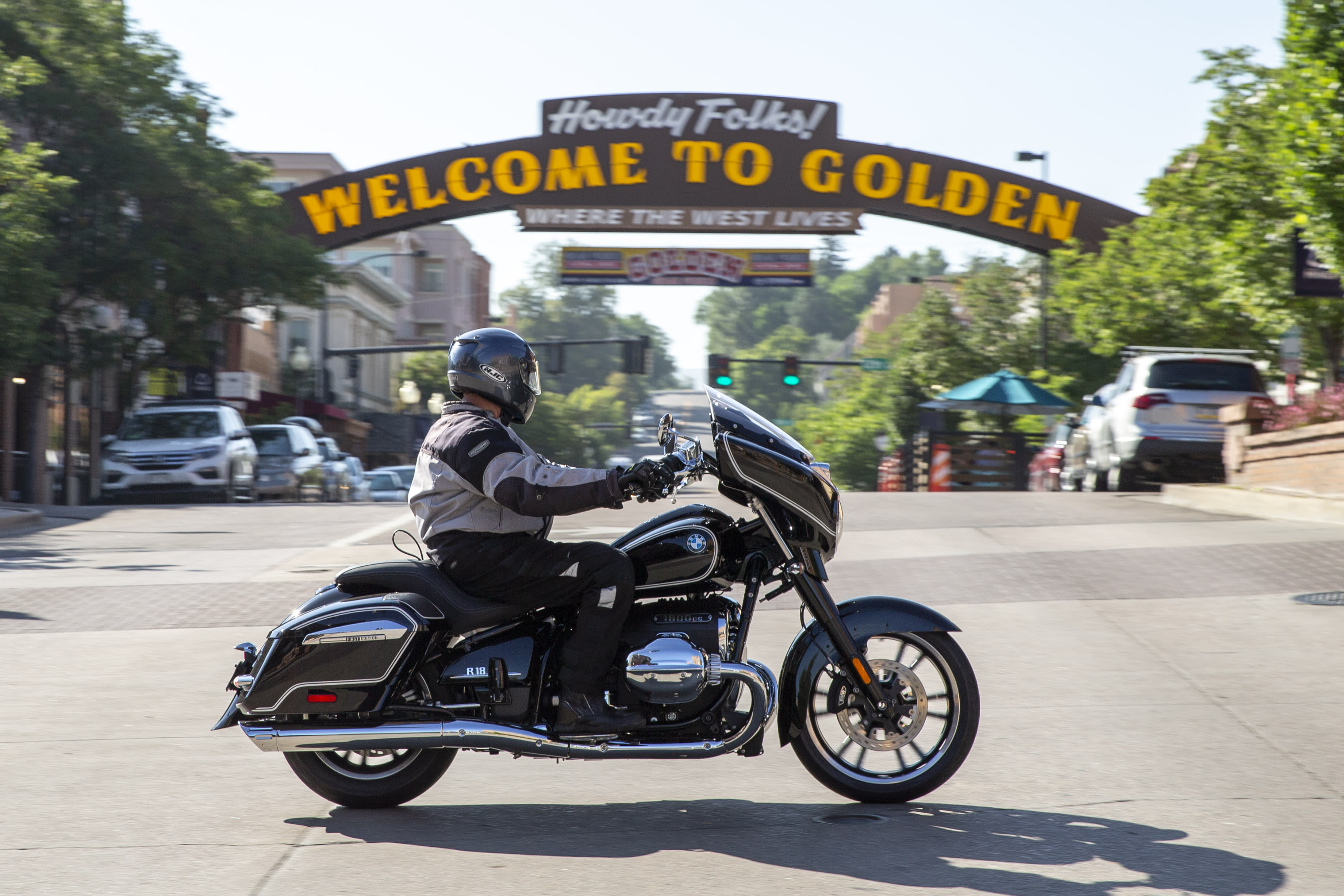 A BMW R 18 B crossing an intersection with a sign for the city of Golden in Colorado in the background