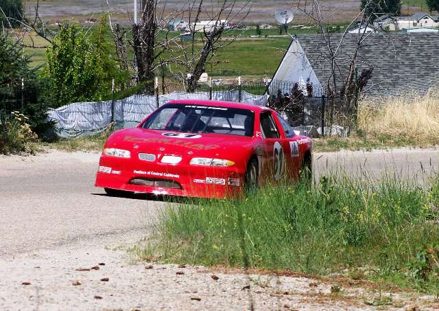 a red pontiac racing up a hill during a hill climb in Idaho.