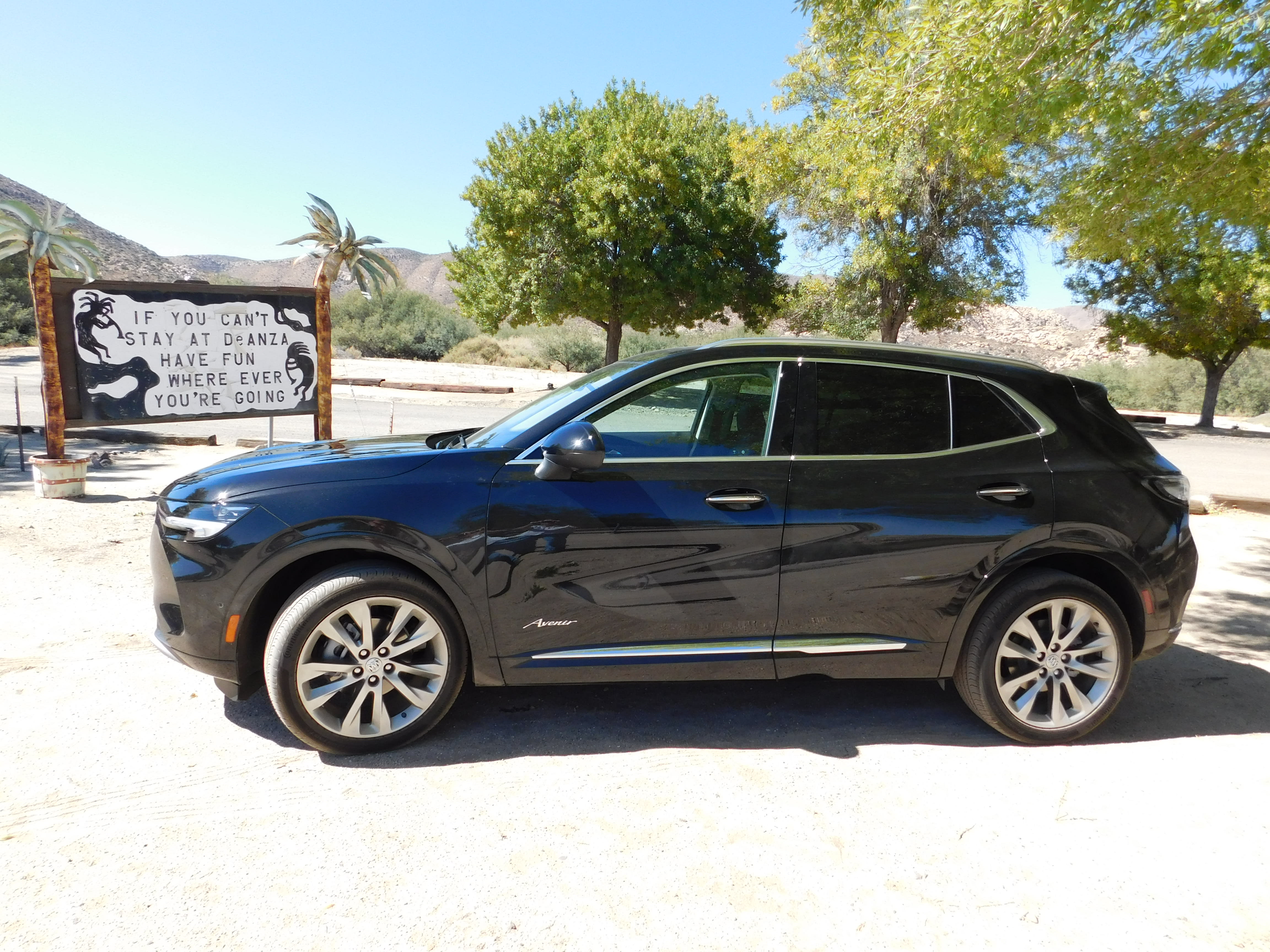the left side of a 2022 Buick Envision Avenir, with the Southern California desertion the background.