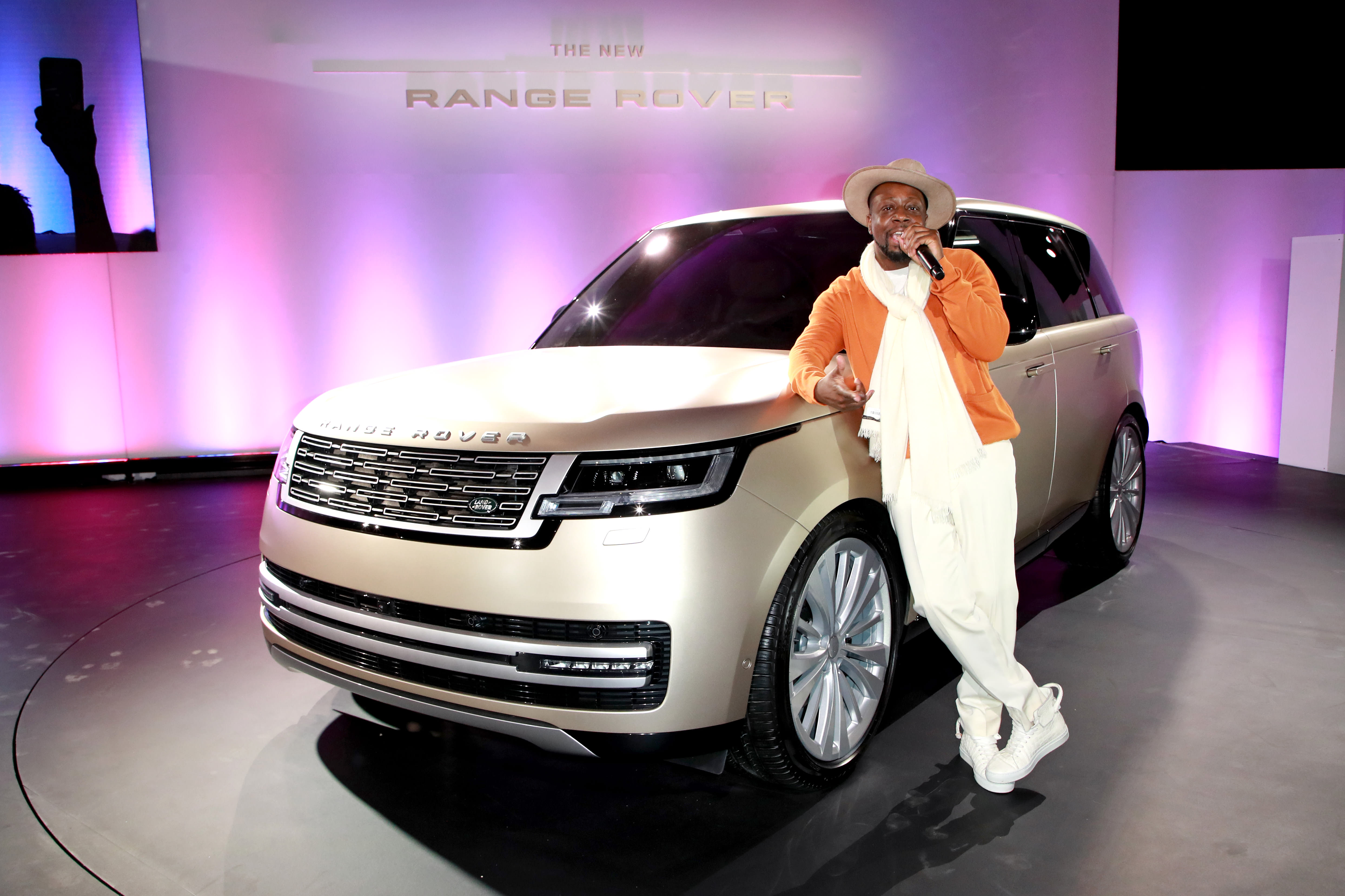 Wyclef Jean posing next to the brand new Land Rover Range Rover at the LA Auto Show 2021.
