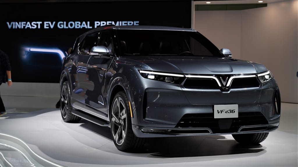the Vinfast global premiere at the LA Auto Show, with a very large, gray, SUV-like electric vehicle on display.