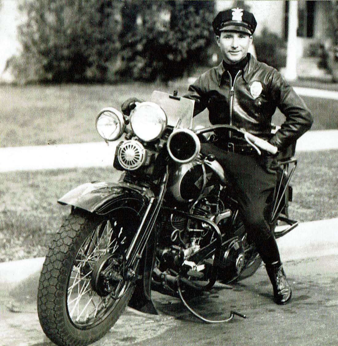 image from the book, featuring Ludlow as a police officer on a motorcycle