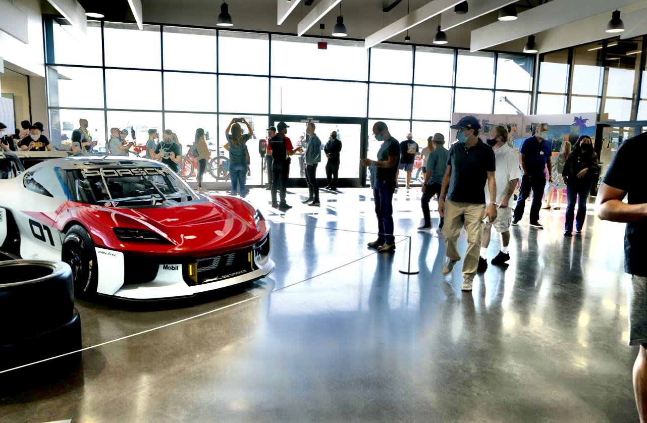 image of the 5th anniversary event at the Porsche Experience Center in Los Angeles, with mutable attendees standing around.