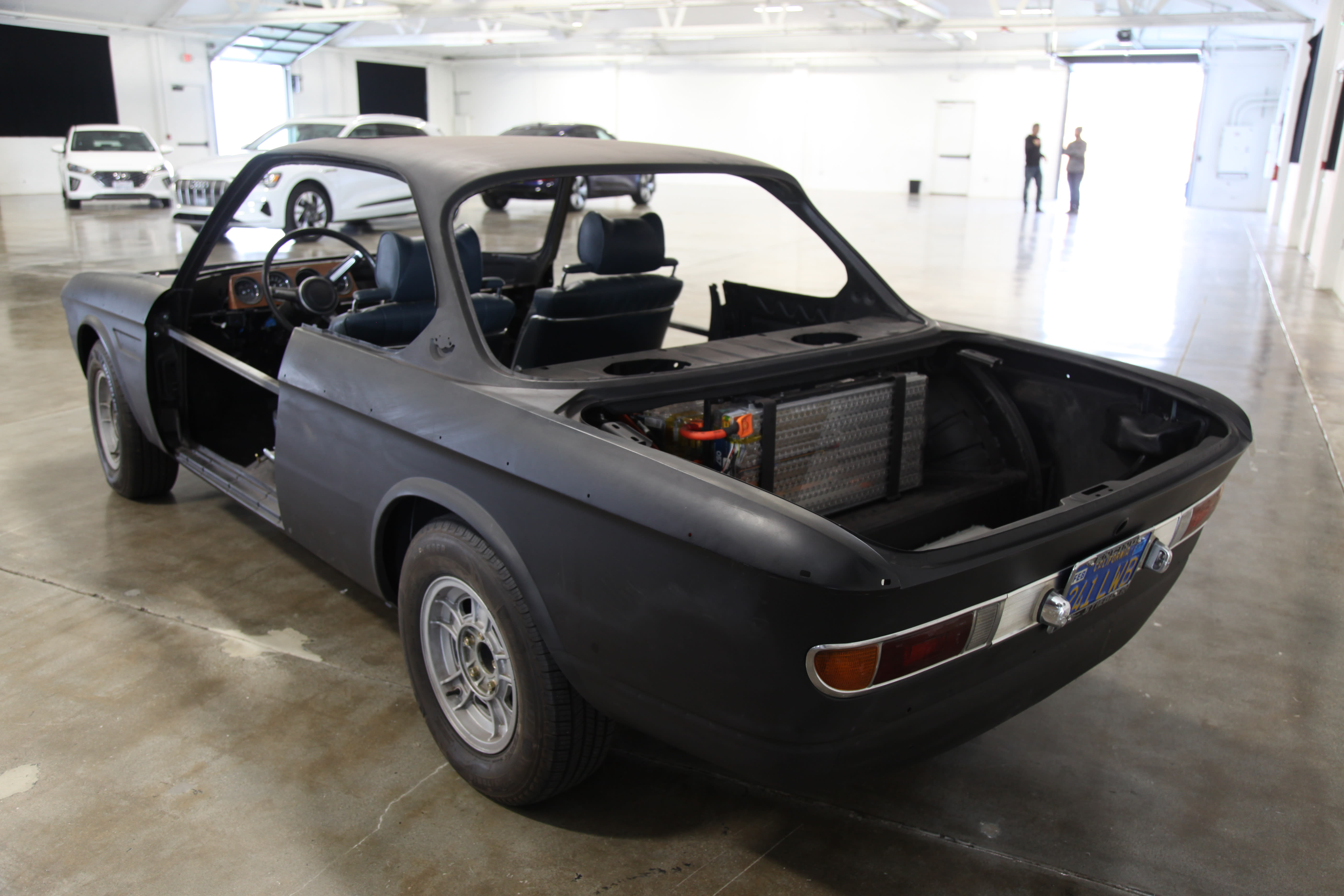 the back of a black BMW, retrofitted for electric propulsion at Autopia 2099.