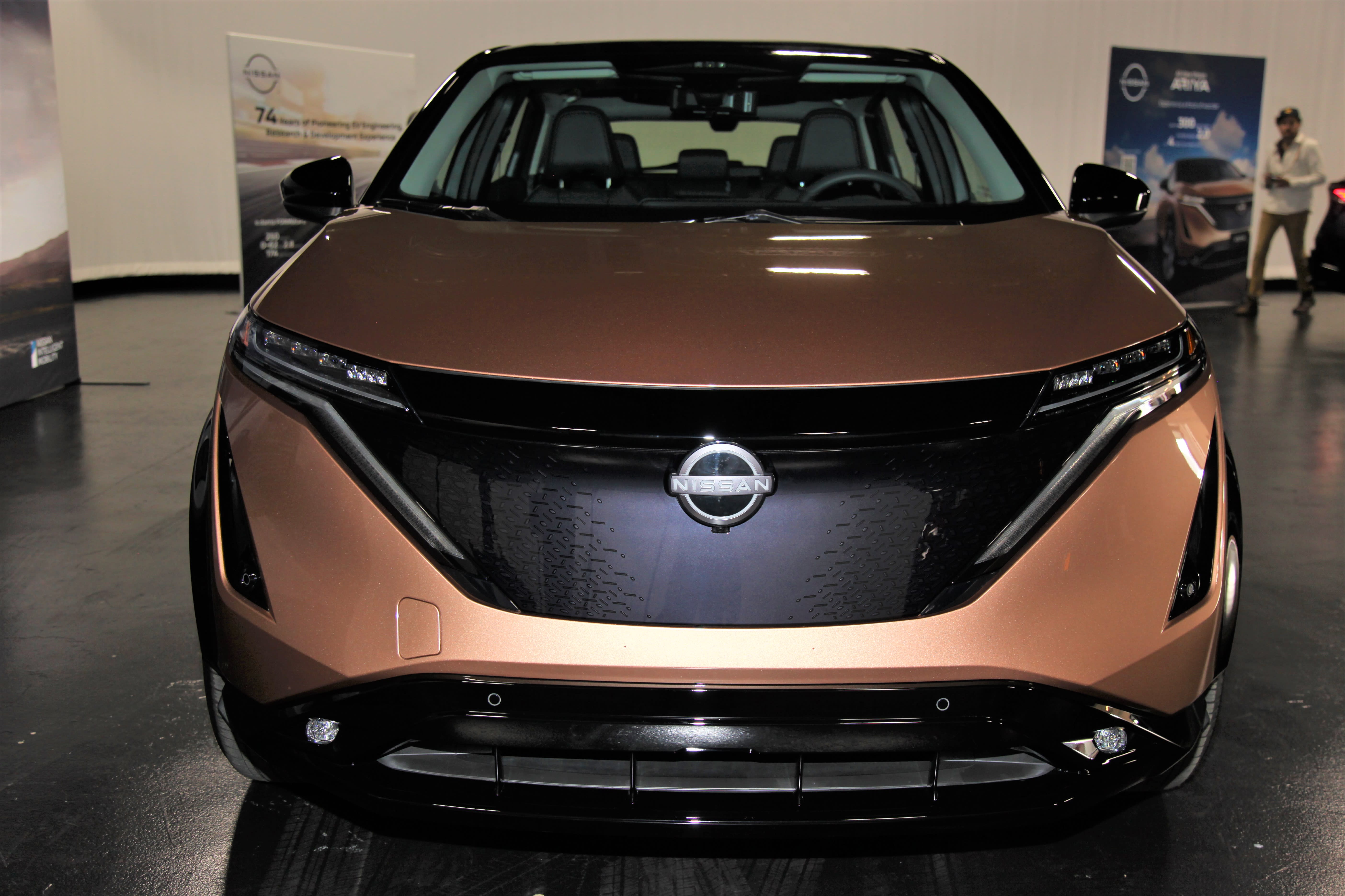 a gold-colored Nissan Ariya displayed at Autopia 2099.