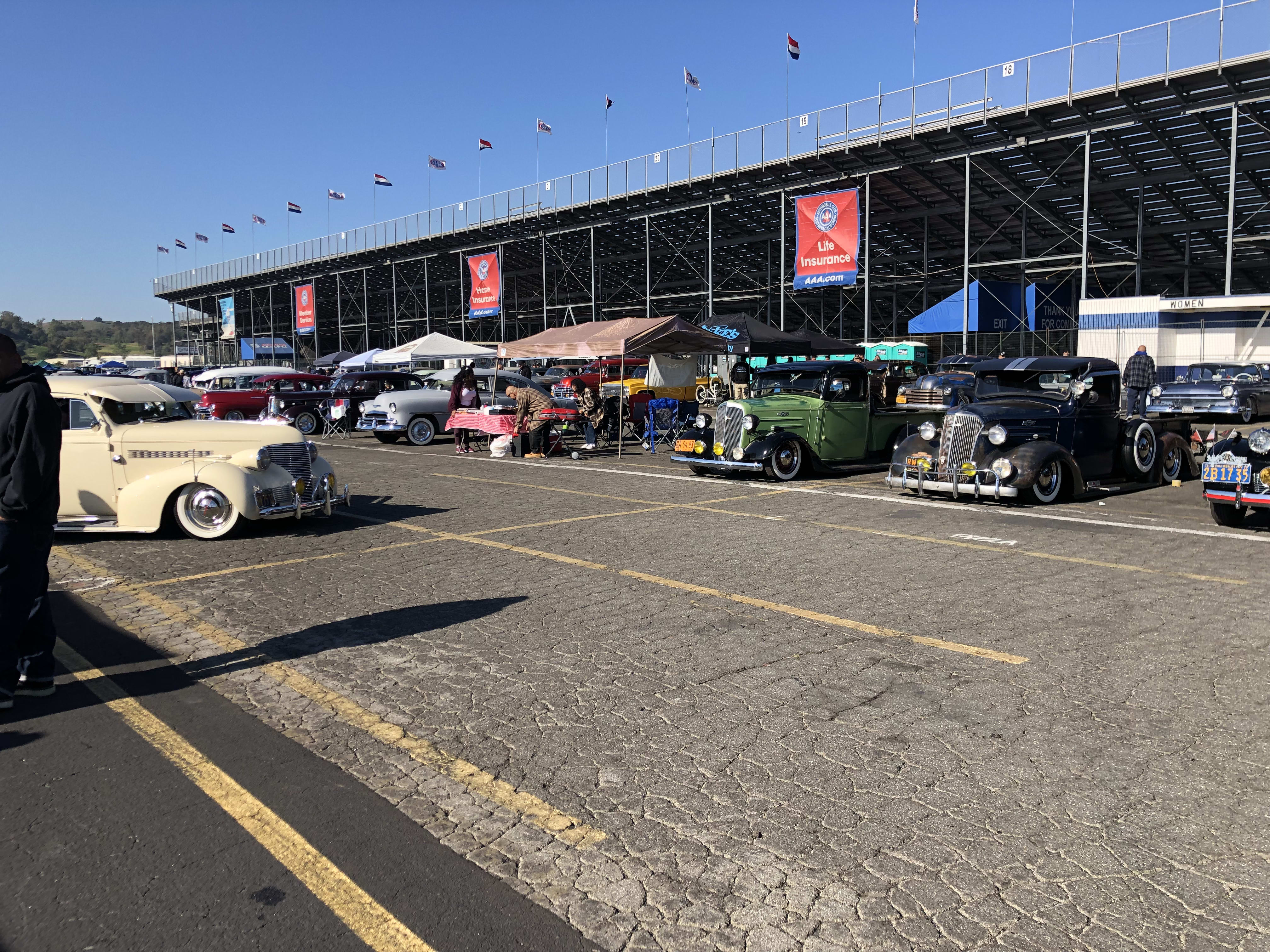 an overview of the Pomona Auto Swap meet, with the backside of the bleachers behind a line of cars