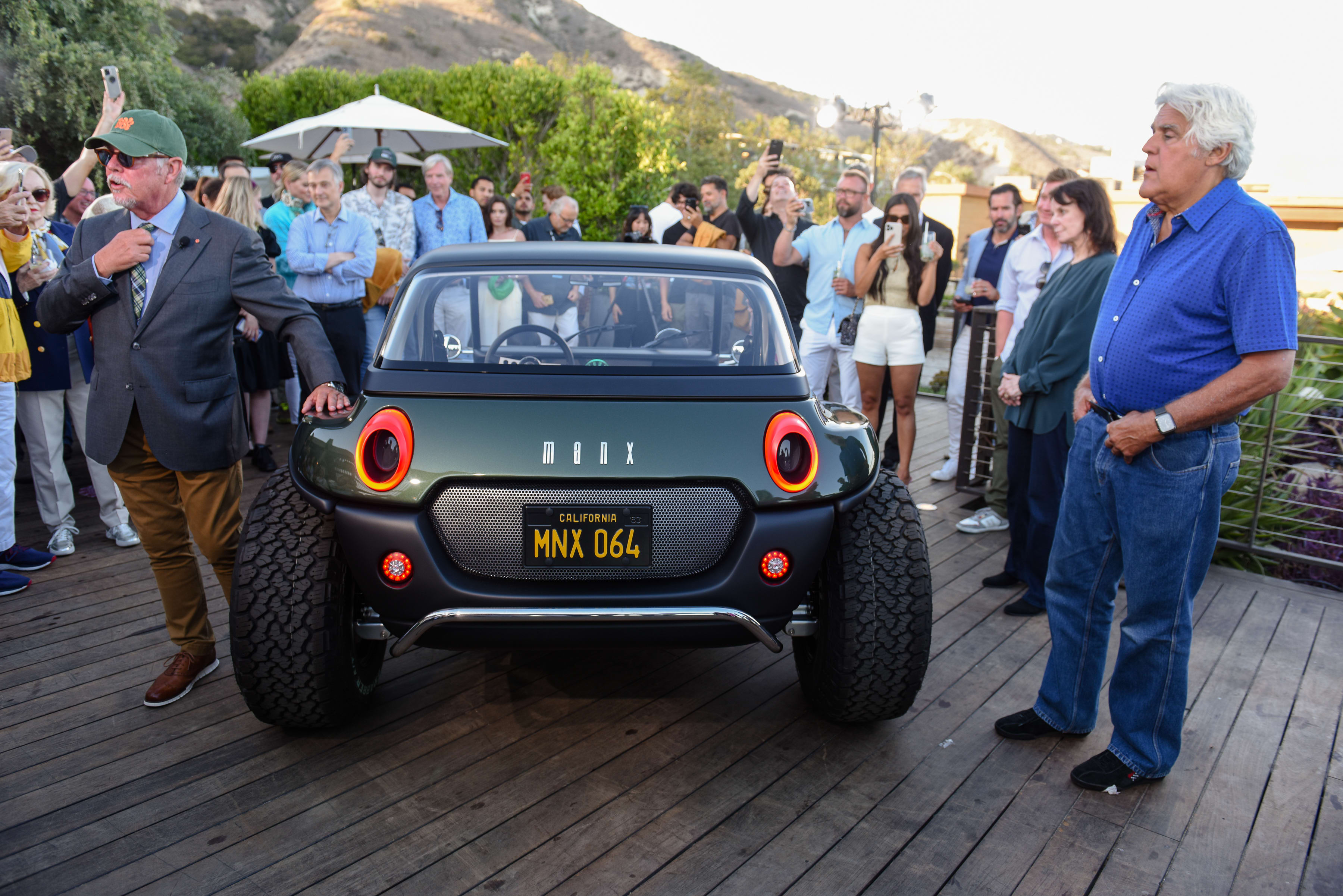 the new and electric Meyers Manx dune-buggy as it was displayed in Malibu, with Jay Leno standing next to it.