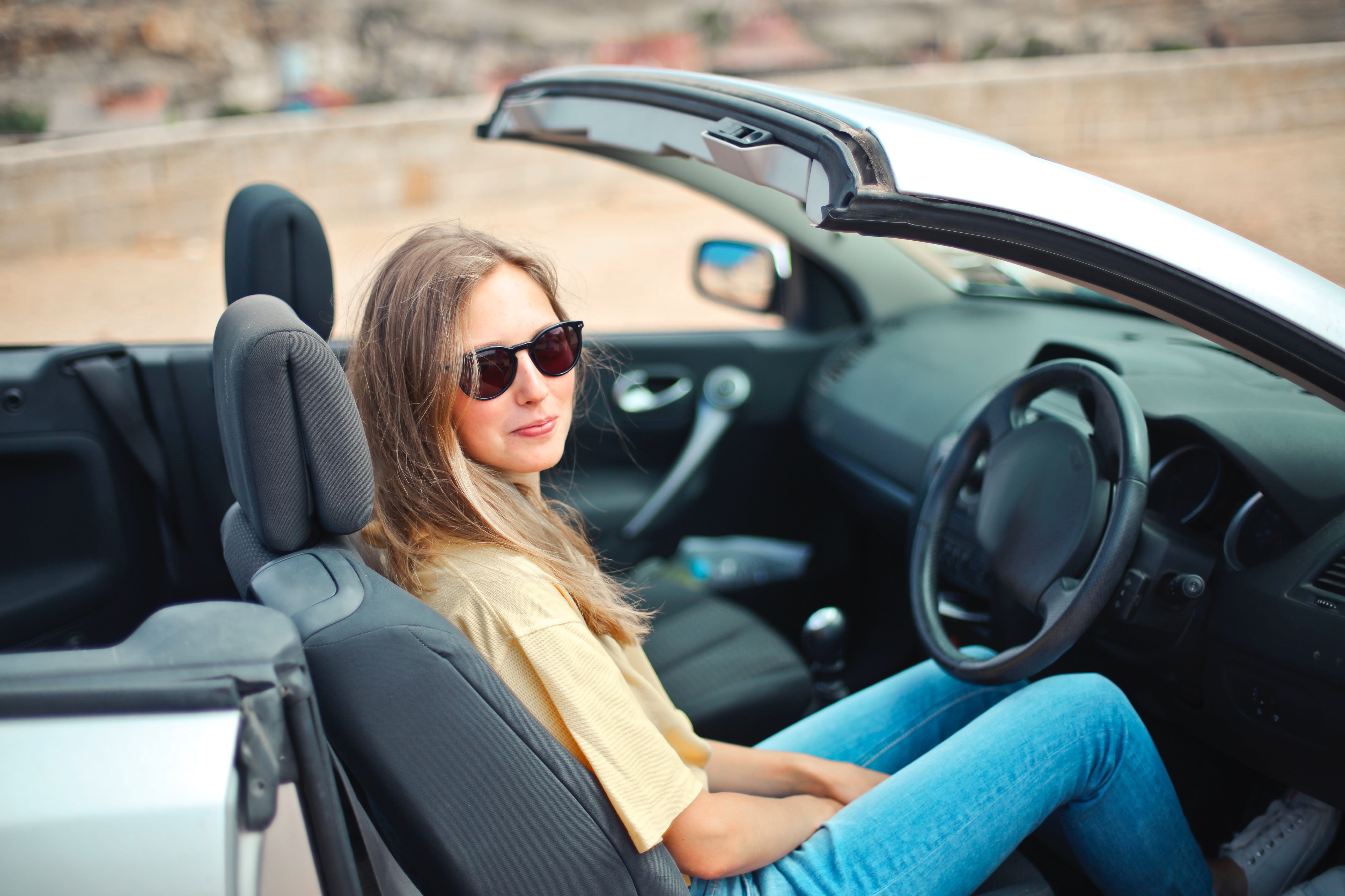young driver behind the wheel in a convertible