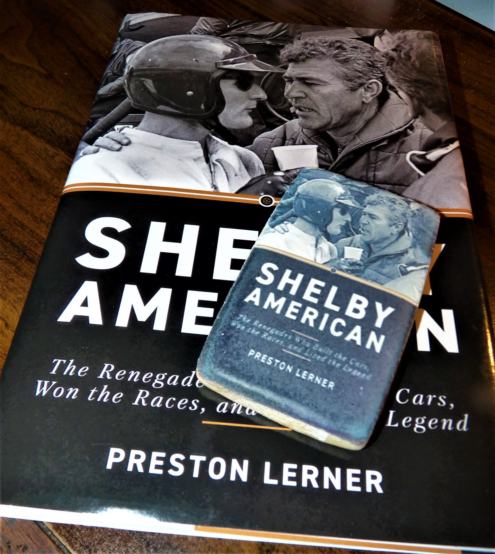 the book Shelby American with a cookie laying on top. The cookie is printed to look like the book.