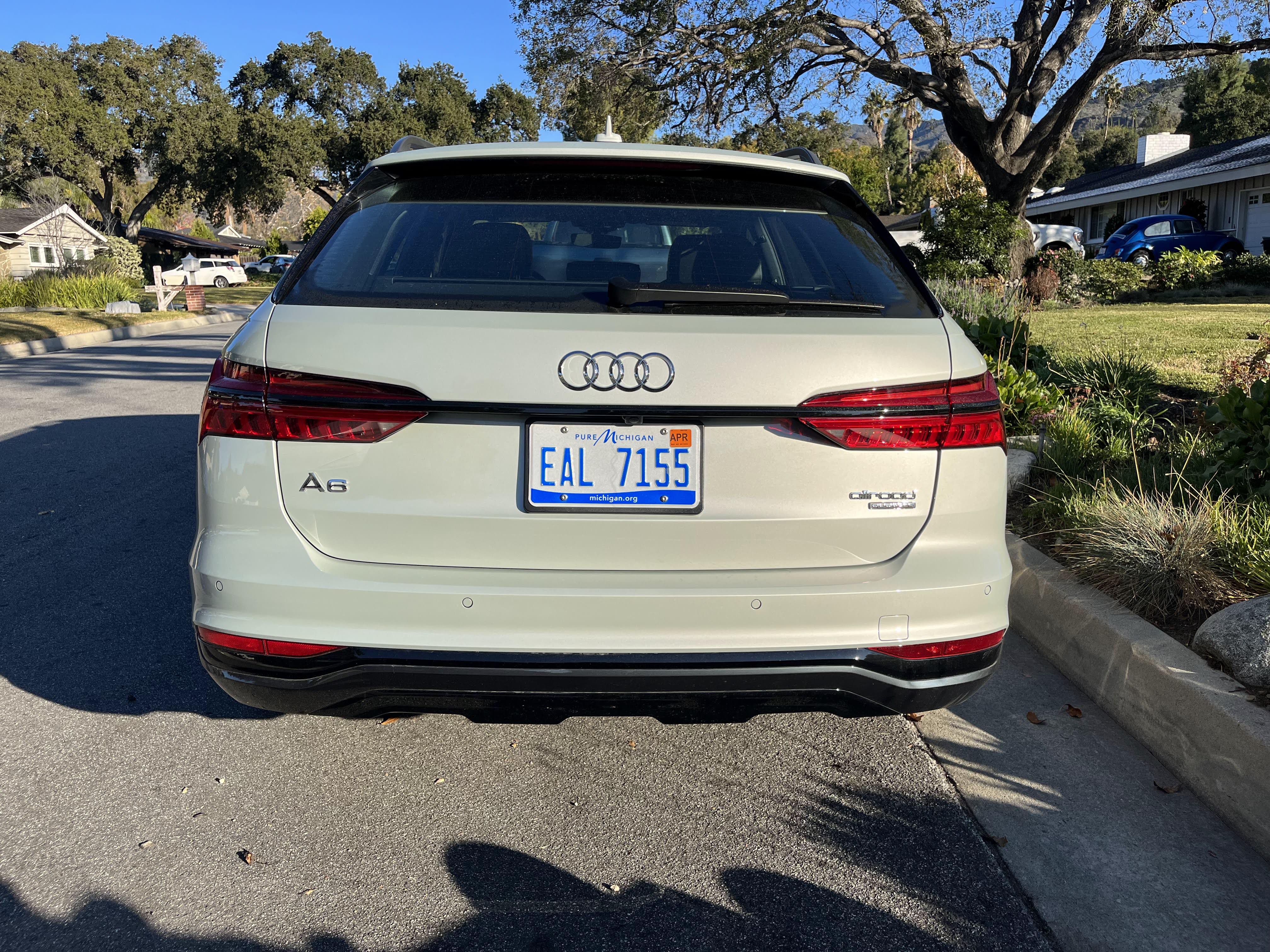 An Audi A6 Allroad, seen from the rear, parked on a street.