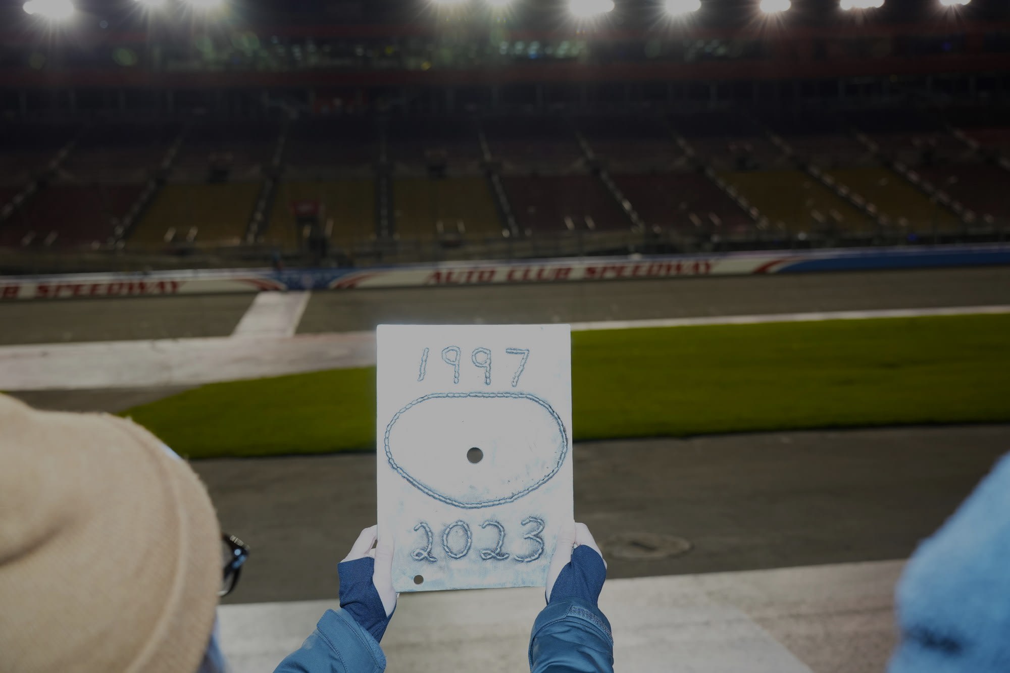 placard showing the years 1997 - 2023 held up after the last race on Auto Club Speedway in Fontana