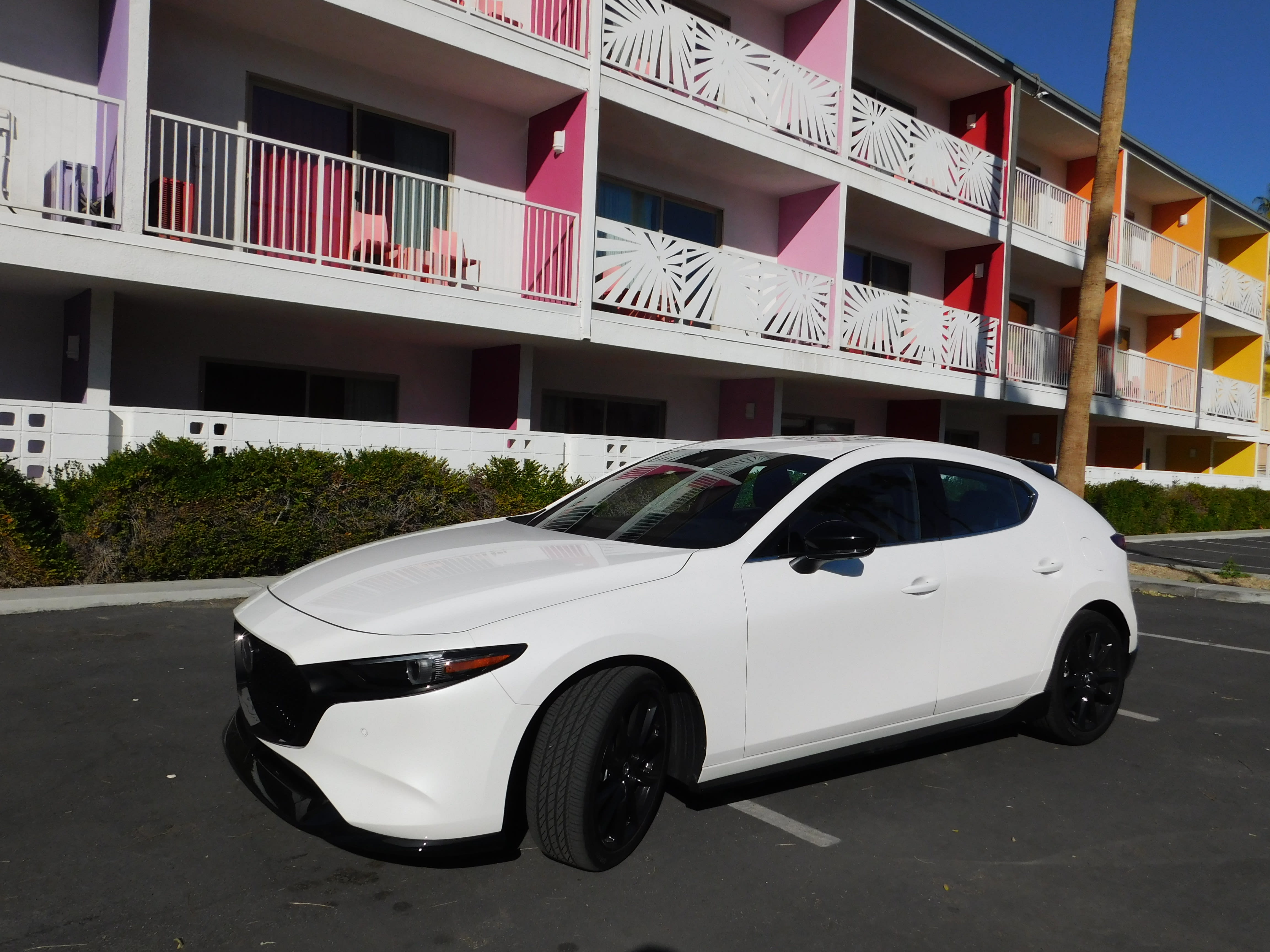 image of the 2023 Mazda3 hatchback Turbo in front of an eclectic hotel in Palm Springs, CA