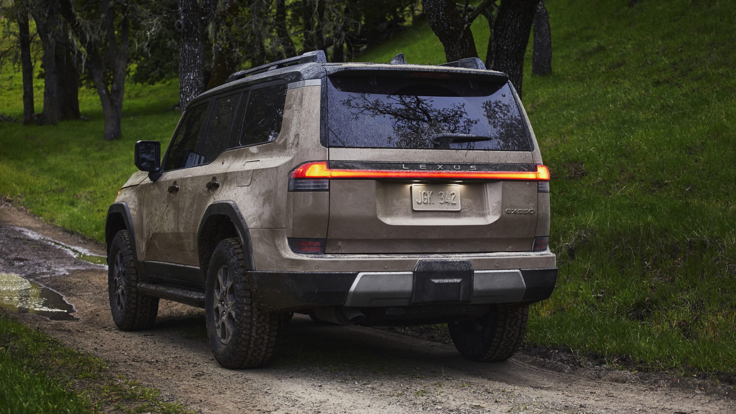 rear of the 2024 Lexus GX driving on a dirt road