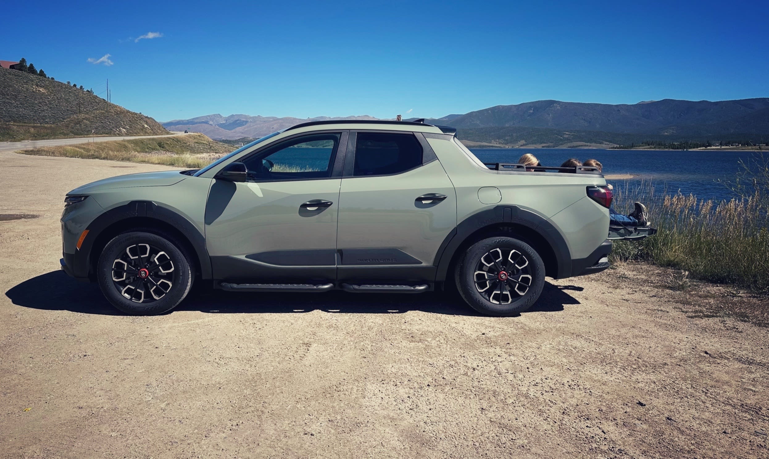 a dark green 2024 Hyundai Santa Cruz with three kids sitting on the tailgate eating ice cream