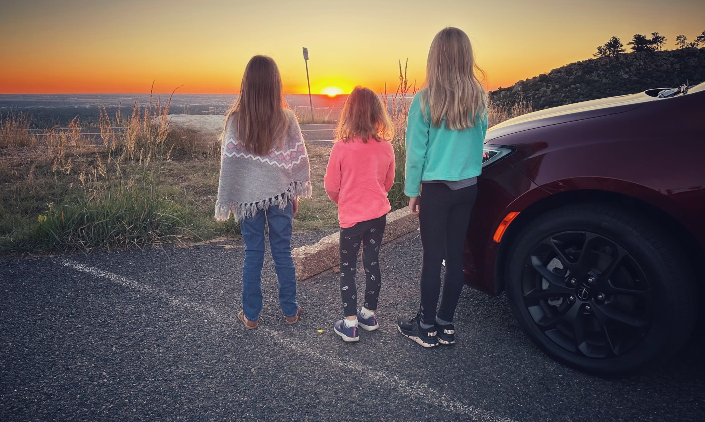 image of three kids by the 2023 Chrysler Pacifica watching a sunrise.