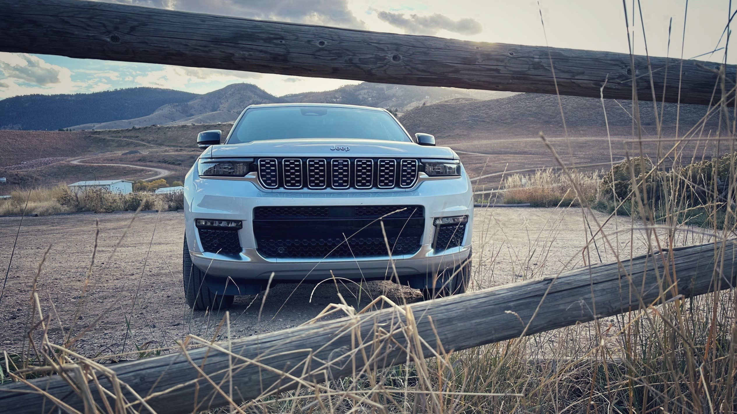 a gray 2023 Jeep Grand Cherokee peeking through a fence