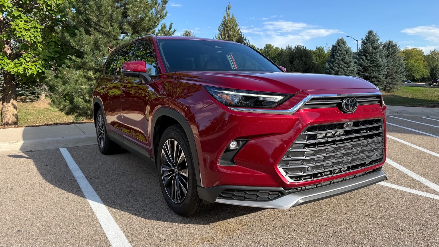 Front passenger-side three-quarter view of the red 2026 Toyota Grand Highlander Hybrid MAX Platinum.
