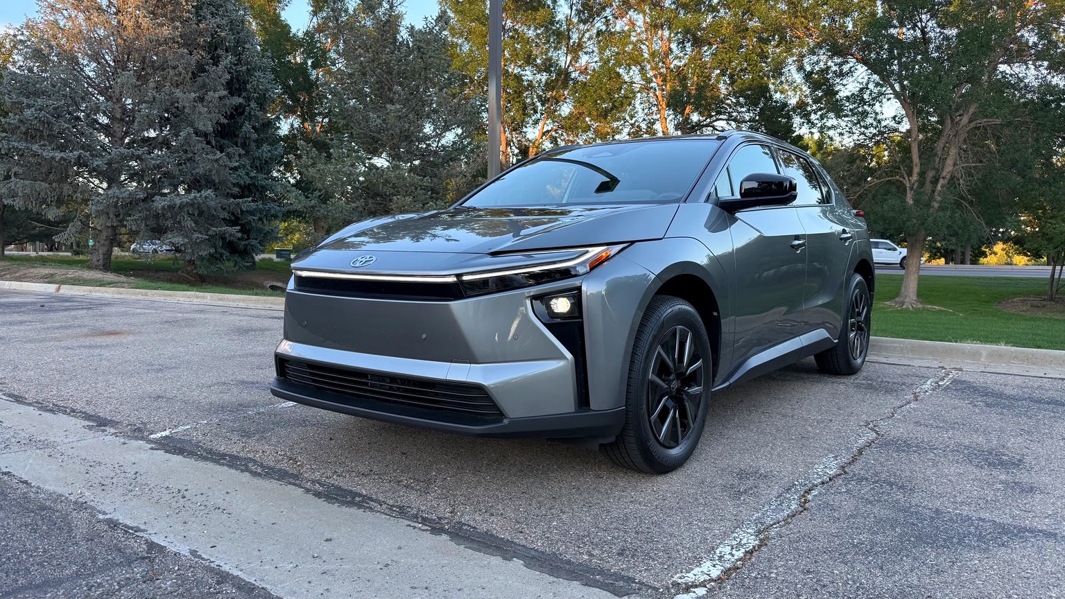 2026 Toyota bZ front three-quarter view with trees behind it.
