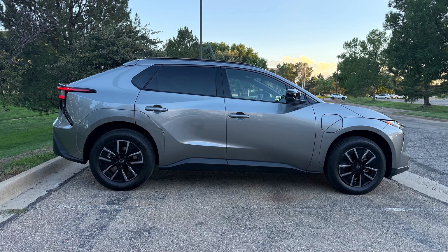 Silver-gray 2026 Toyota bZ in side profile with dark wheels and rear windows.