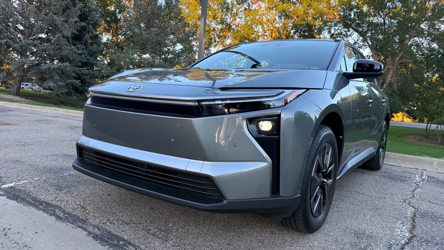 Close front three-quarter view of the 2026 Toyota bZ nose, headlight and front wheel.