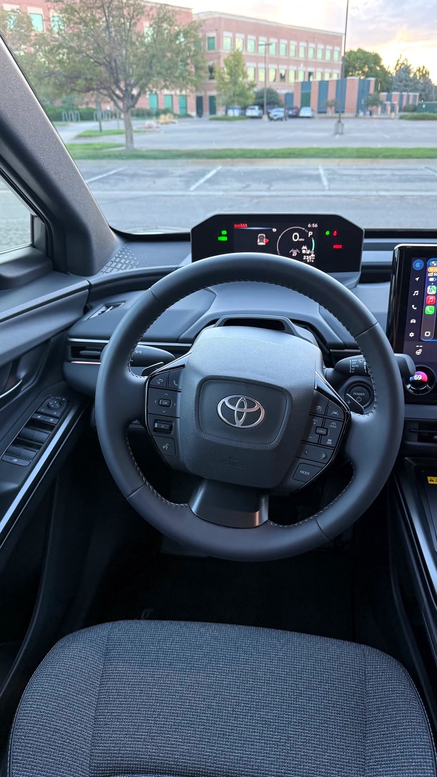 2026 Toyota bZ steering wheel beneath a high-mounted digital instrument display.