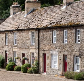 An external shot of cottages with red doors.