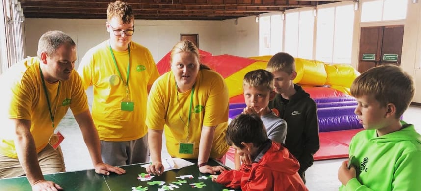 Community support workers doing a puzzle with kids