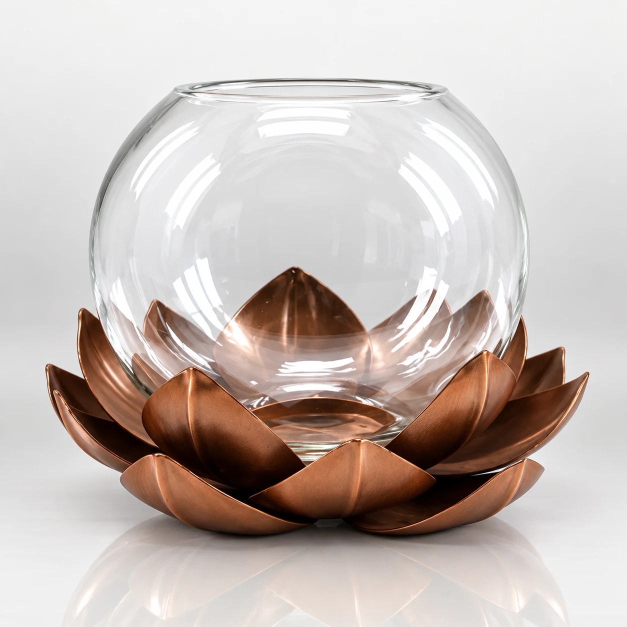 Clear glass hurricane candle holder with copper-toned lotus-style metal base