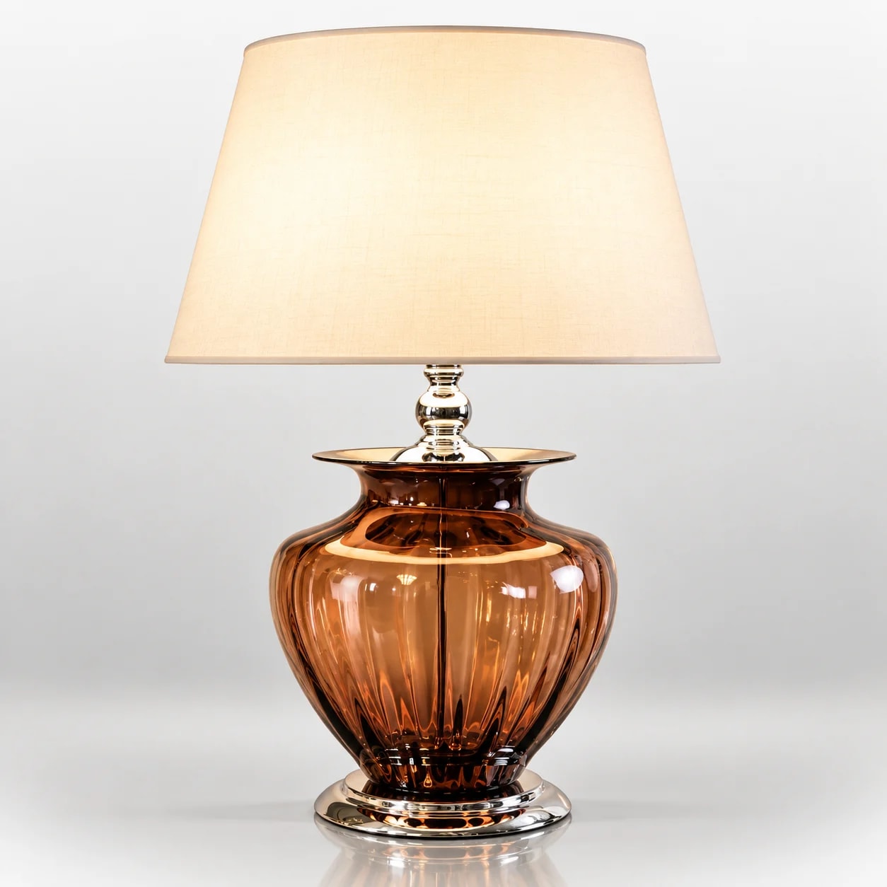 Amber glass table lamp with metallic accents and fabric shade