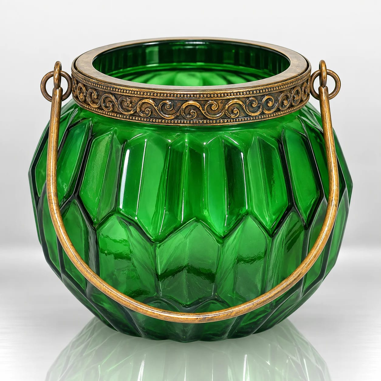 Emerald green faceted glass candle holder with an ornate antique gold rim and curved gold handle.