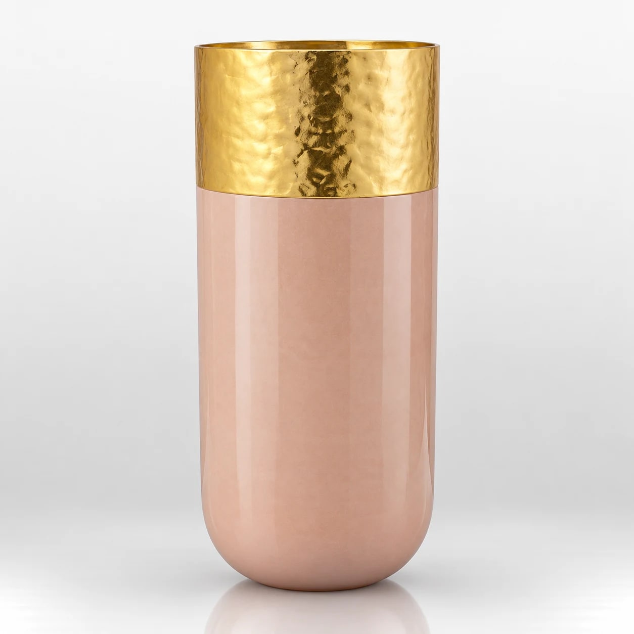 Blush pink cylindrical candle holder with a hammered gold-tone upper section and smooth rounded body.