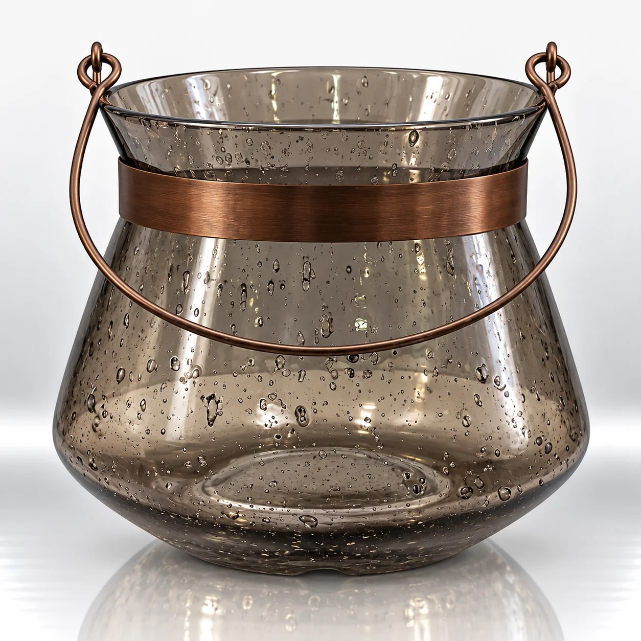 Smoky grey bubble-textured glass candle holder with a bronze metal band and curved handle against a light background.